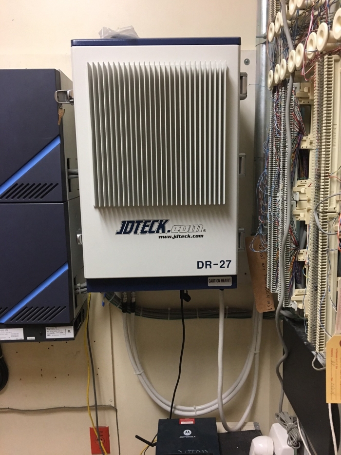 Quad Band 27dBm Digital Repeater installed neatly in the corner of communications room. All Wireless Service Providers (WSP's) supported but individually optimized with just one repeater. Remote access capabilities via Ethernet allows for the implementation of a monitoring and maintenance contract.  